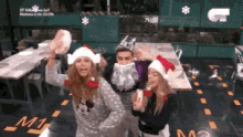 a group of people wearing santa hats are dancing