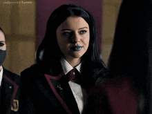 a girl with blue lipstick on her lips is wearing a black jacket and tie