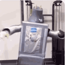 a robot is standing in front of a machine with a bottle of water on it 's back .