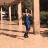 a woman in a blue dress is dancing on a porch