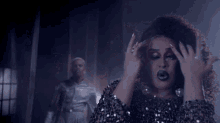 a woman wearing a sequined top is making a funny face