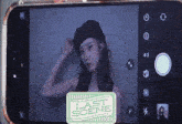 a woman is taking a picture of herself with a last scene sticker