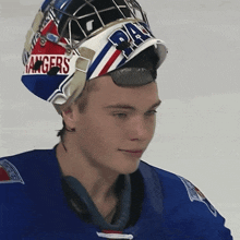 a hockey player wearing a helmet that says rangers
