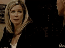 a man and a woman are touching each other 's arms in a room .