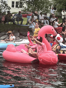 a woman in a pink flamingo float is sitting in the water