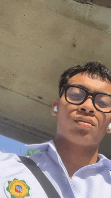 a young man wearing glasses and a white shirt has a badge on his shirt that says ' philippines ' on it