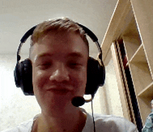 a man wearing headphones and a microphone is smiling for the camera