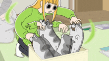 a girl in a green sweater is petting a box of cats