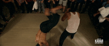 a poster for kahar shows two men fighting in front of a crowd of people