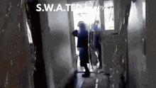 a s.w.a.t.f.i. officer stands in a hallway