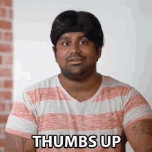 a man in a striped shirt is giving a thumbs up