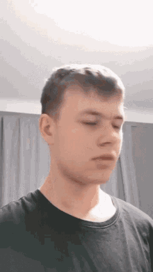 a young man wearing a black shirt is looking down