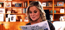 a woman is reading a newspaper and says " and the groom wore a butt so perfect it could make an angel hangitself "