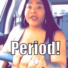 a woman is sitting in a car with the word period written on the screen
