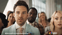 a man in a suit and tie stands in front of a crowd of people with the hashtag #grossepointegardensociety on the bottom