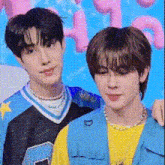 a couple of young men are standing next to each other .