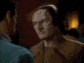 a man is hugging another man with a mask on his face .