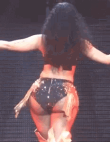 a woman is dancing on a stage with her arms outstretched