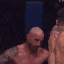 two men are fighting in a boxing ring and one of them is laying on the ground .
