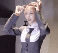 a woman in a suit and tie is holding her hair