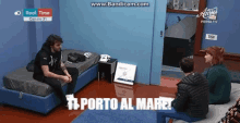 a man sits on a bed in a room with a sign that says ts porto al mare