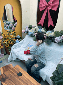 a woman sits on a couch with flowers on it