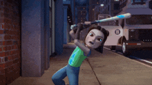 a girl in a green shirt is holding a baseball bat