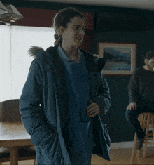 a woman wearing a blue sweatshirt that says ' the north face ' on the front