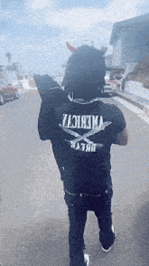 a man in a devil costume is walking down a street .