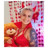 a woman in a red bra is smiling while holding a teddy bear .