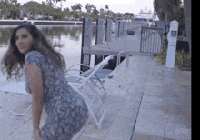 a woman in a snake print dress is dancing on a dock
