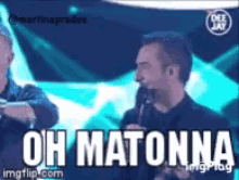 a man speaking into a microphone with the words oh matonna written below him