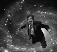 a man in a suit and tie is flying through the air in a black and white photo