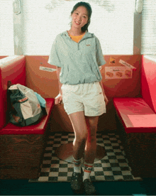a woman standing in a diner with a kodak sign on the wall behind her
