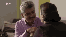 a man and a woman are looking into each other 's eyes with a hd logo in the background