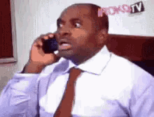 a man in a suit and tie is talking on a cell phone