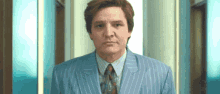a man in a blue striped suit and tie looks at the camera