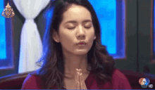 a woman prays with her eyes closed in front of a screen that says hd