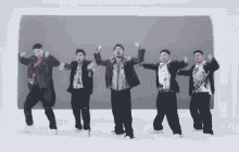 a group of men are dancing in a line with their hands in the air
