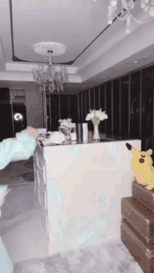 a pikachu stuffed animal is sitting on a trunk in a room