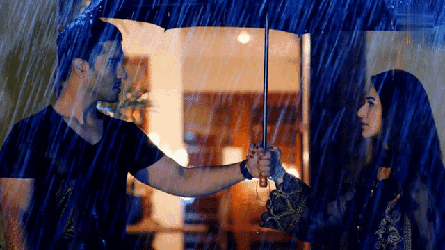 a man holds an umbrella over a woman 's head in the rain
