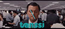 a man in a suit and tie stands in front of a crowd with the word tanssi in blue