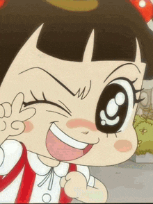 a close up of a cartoon girl making a peace sign with her hand