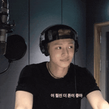 a man wearing headphones and a black t-shirt with korean writing