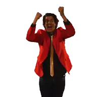 a man in a red jacket and tie is raising his fist in the air