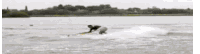 a person is riding a wave on a surfboard in the water .