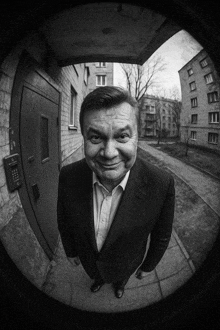 a man in a suit stands in front of a door that has a keypad on it