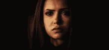 a close up of a woman 's face in a dark room .