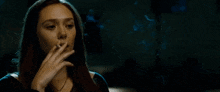 a woman smoking a cigarette with blue smoke behind her