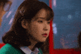 a close up of a woman 's face with a green sweater